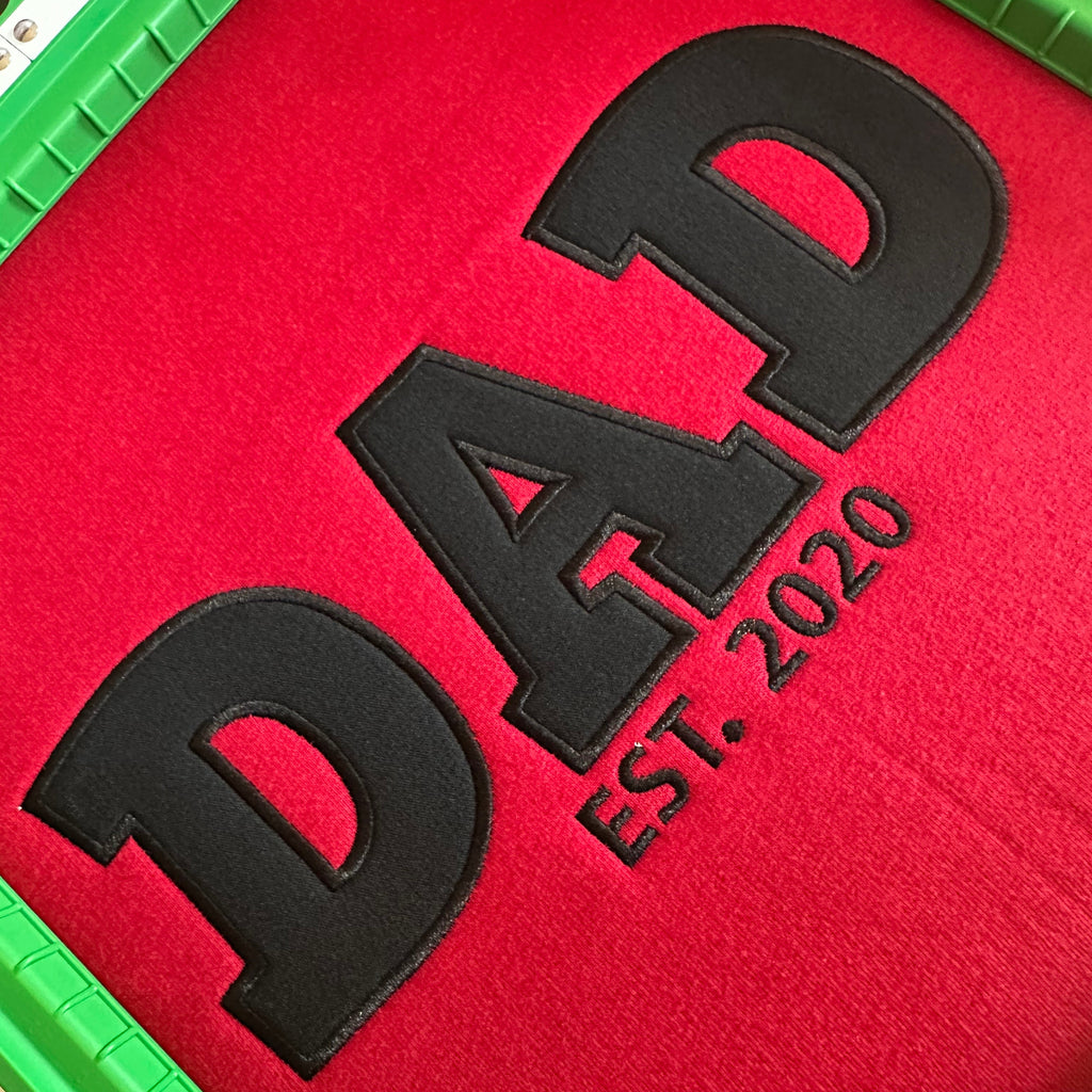 Red hoodie with black 'DAD EST. 2020' text in an embroidery frame