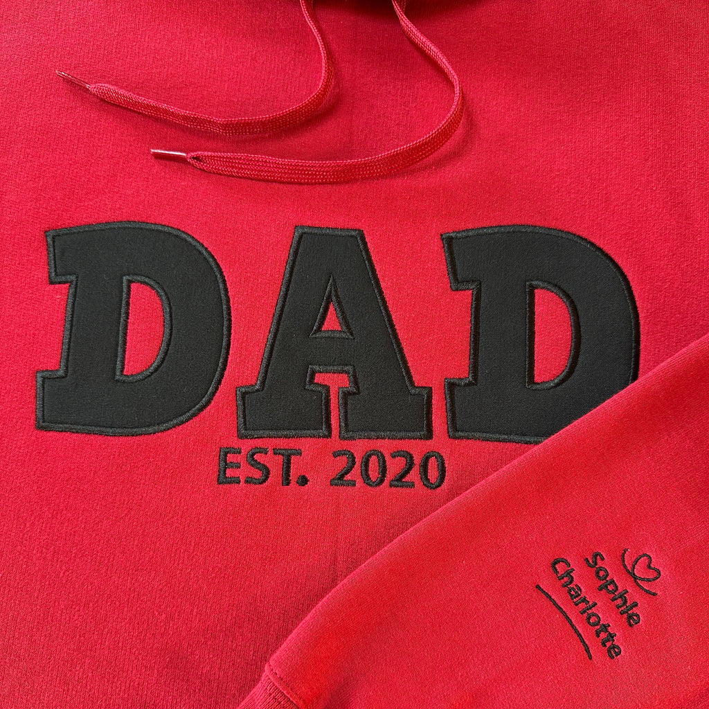Red hoodie with 'DAD EST. 2020' text and names on the sleeve