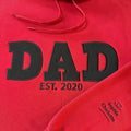 Red hoodie with 'DAD EST. 2020' text and names on the sleeve
