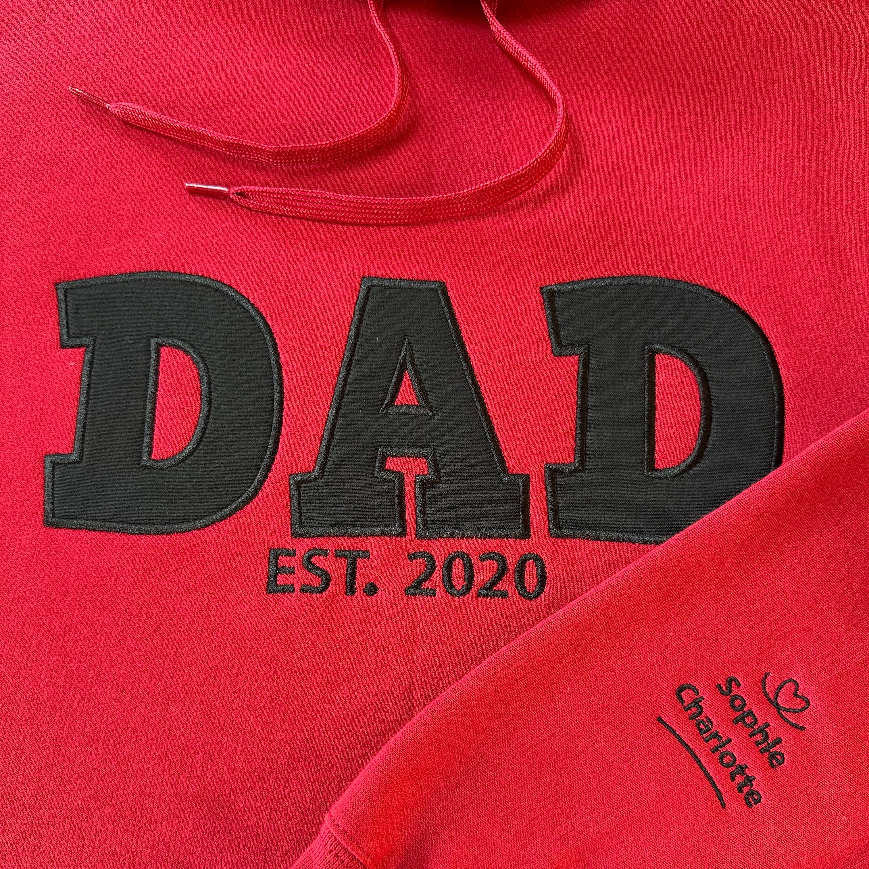 Red hoodie with 'DAD EST. 2020' text and names on the sleeve
